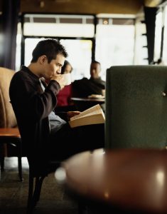 Young Man Reading in Coffee House